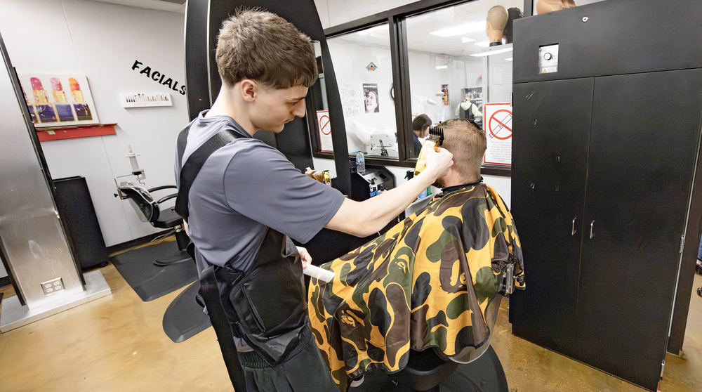 NHS student gives a haircut during Dragon Salon