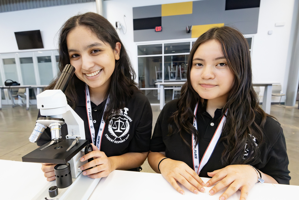 Students shown with microscope
