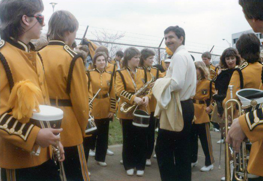Photo of band members around director