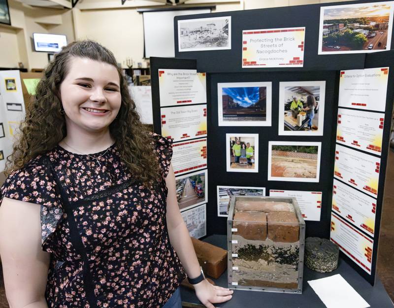 Student in front of project