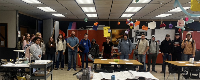 High school students pose for a group photo with guest speaker Aaron Fuller in the art classroom