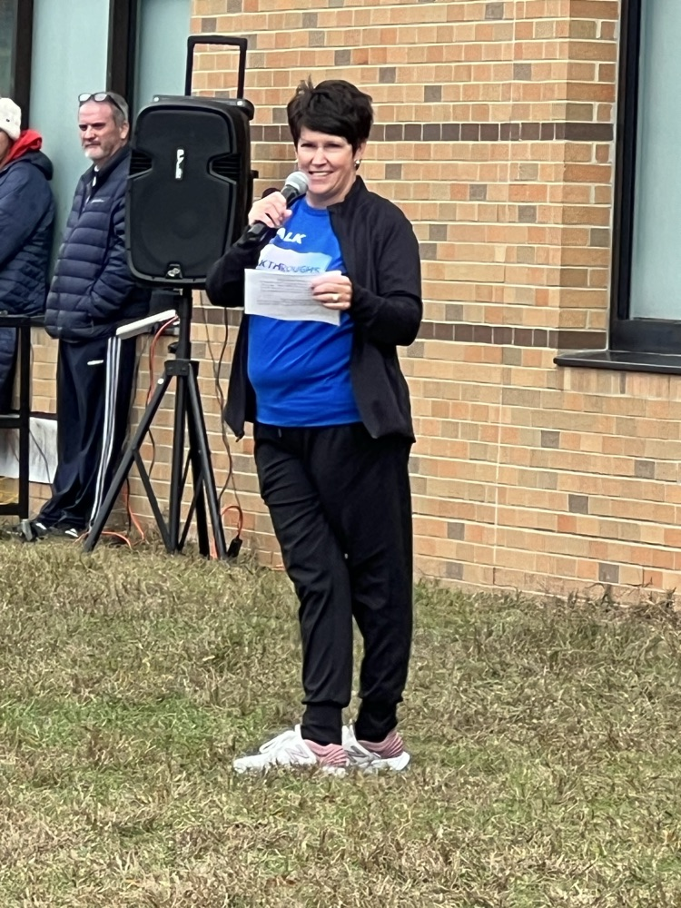 woman talking with mic in front of building