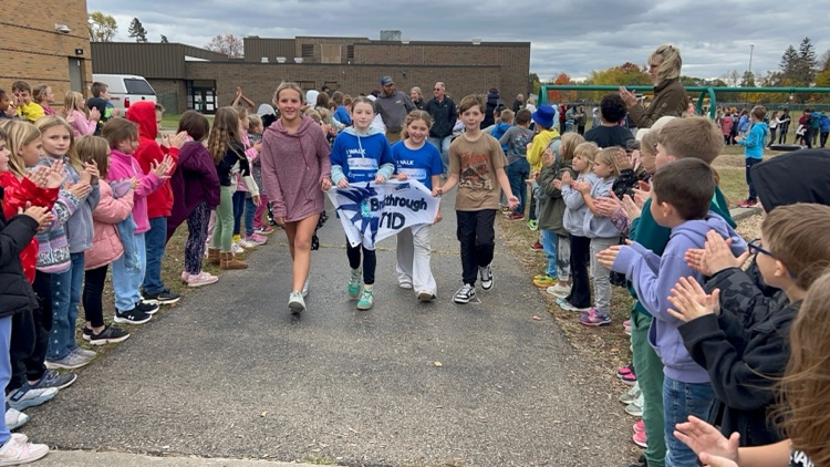 kids holding a T1D banner walking on a track