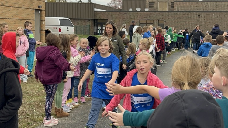 kids giving each other high fives on the track at school