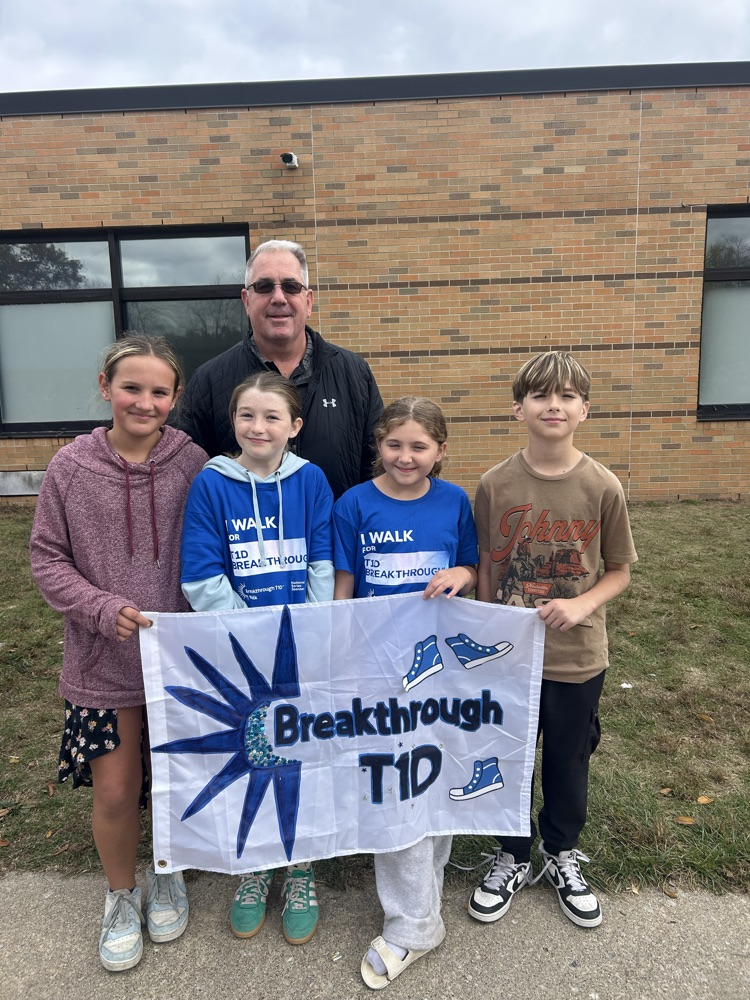 kids holding banner with a man standing behind them