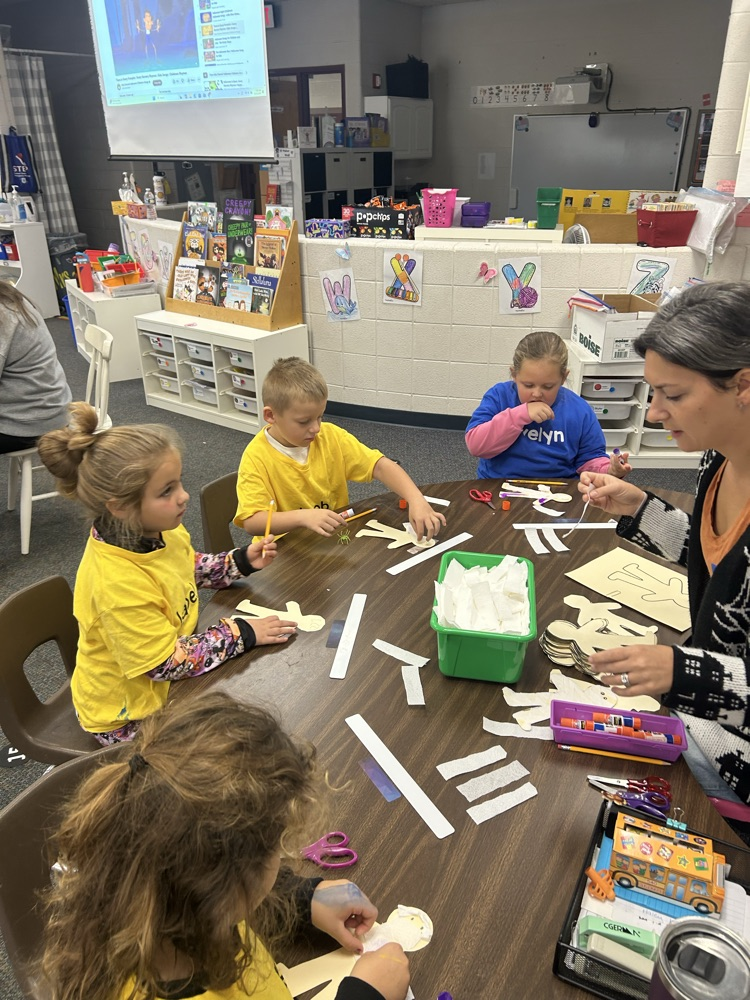 students working on projects at a table with adult