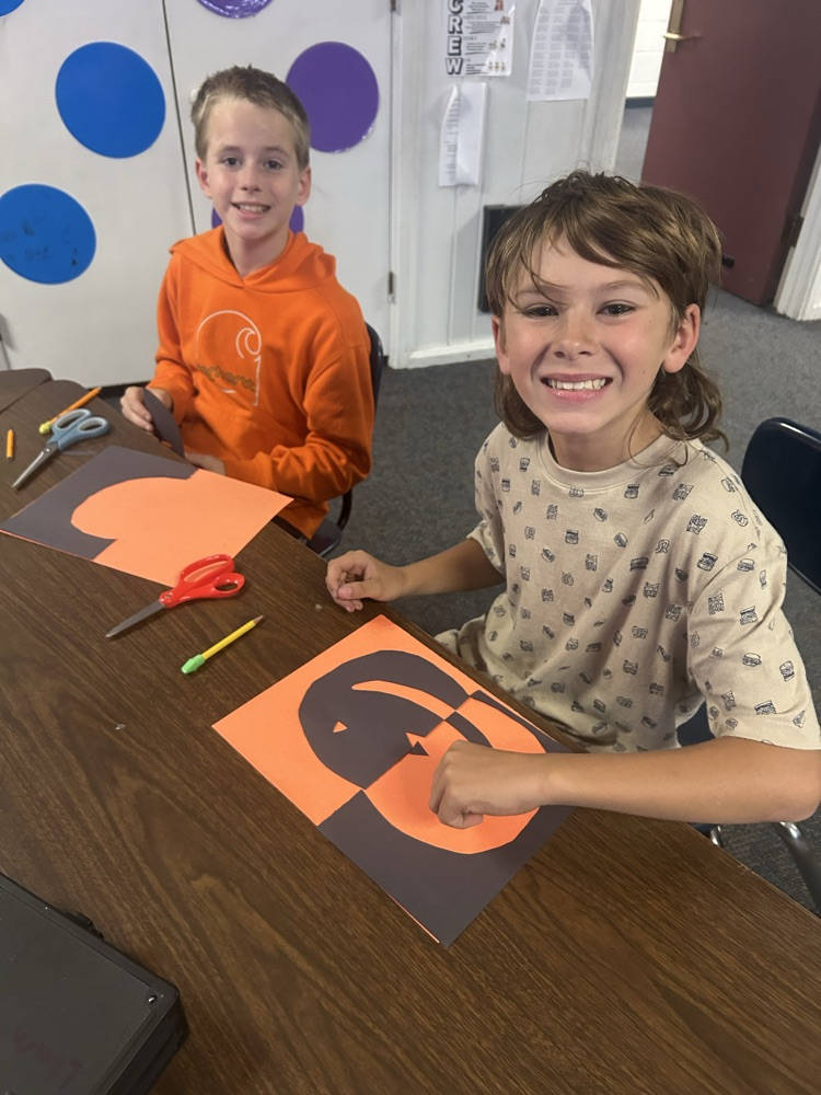 student smiling with pumpkin project