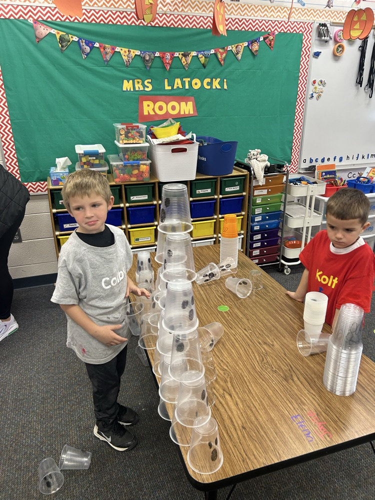 student building a cup tower