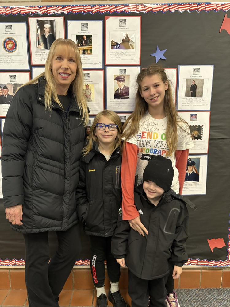 family standing in front of Veterans Day bulletin board