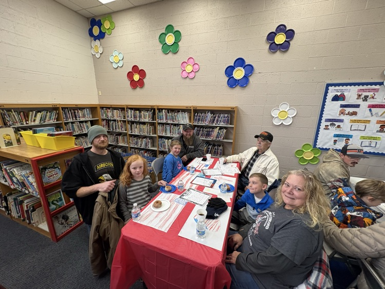 people sitting at table for Veterans Day celebration 