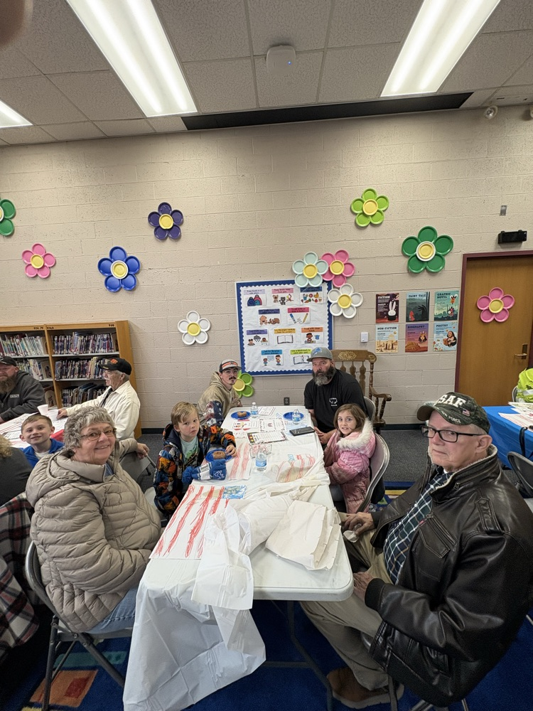 people sitting at table for veterans day celebration 