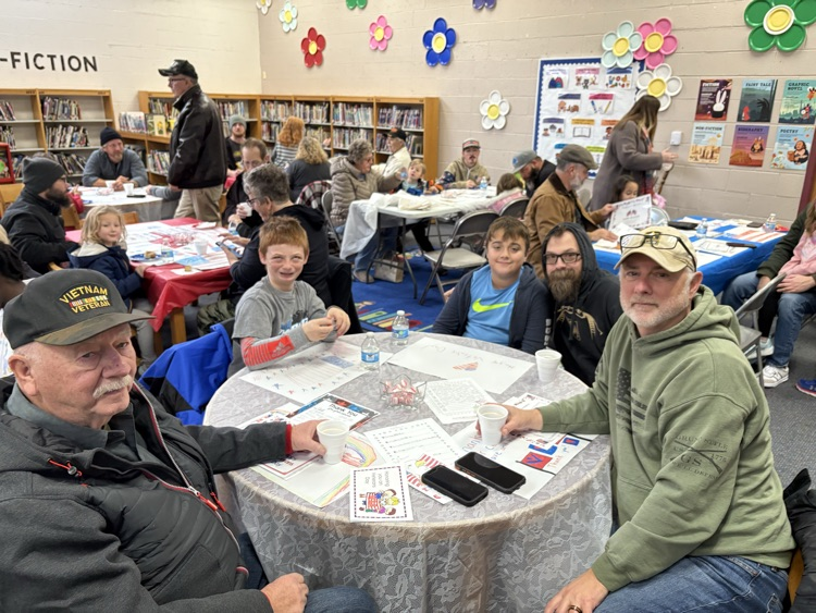 people sitting at table to celebrate Veterans day