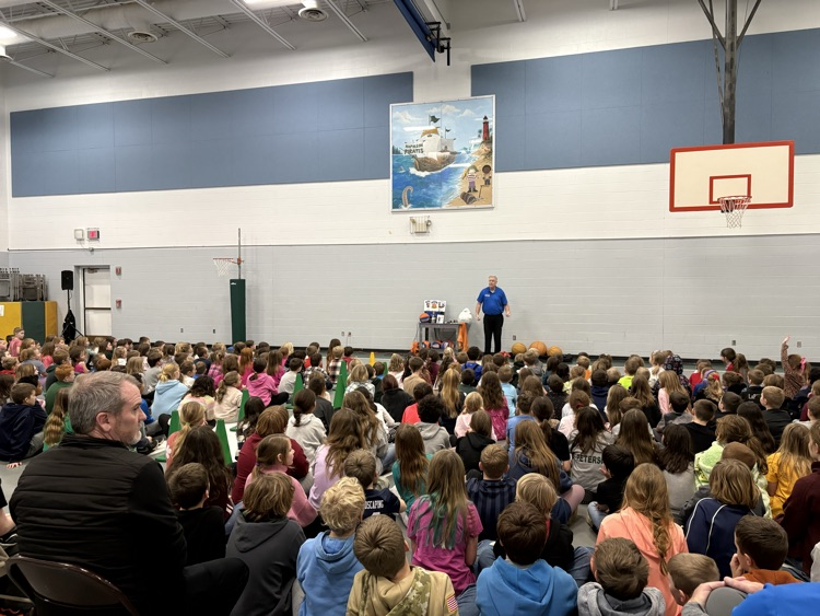 students watching man perform basketball tricks