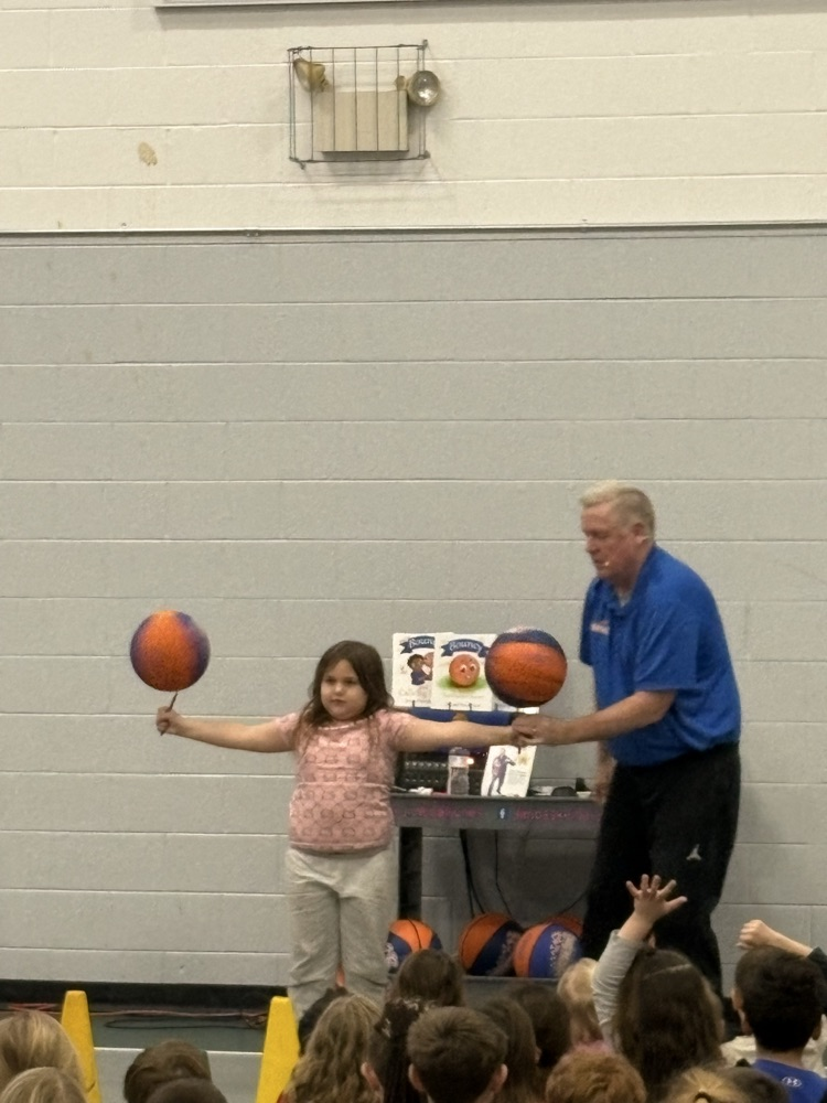 man helping girl balance two basketballs