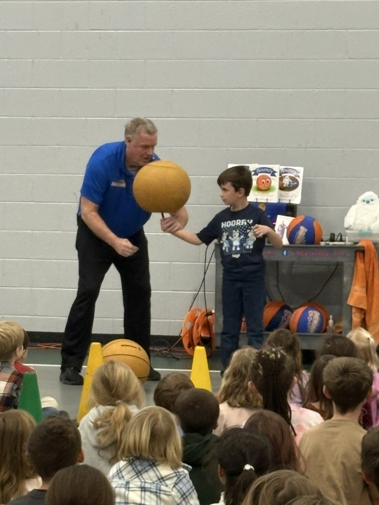 man helping boy balance basketball