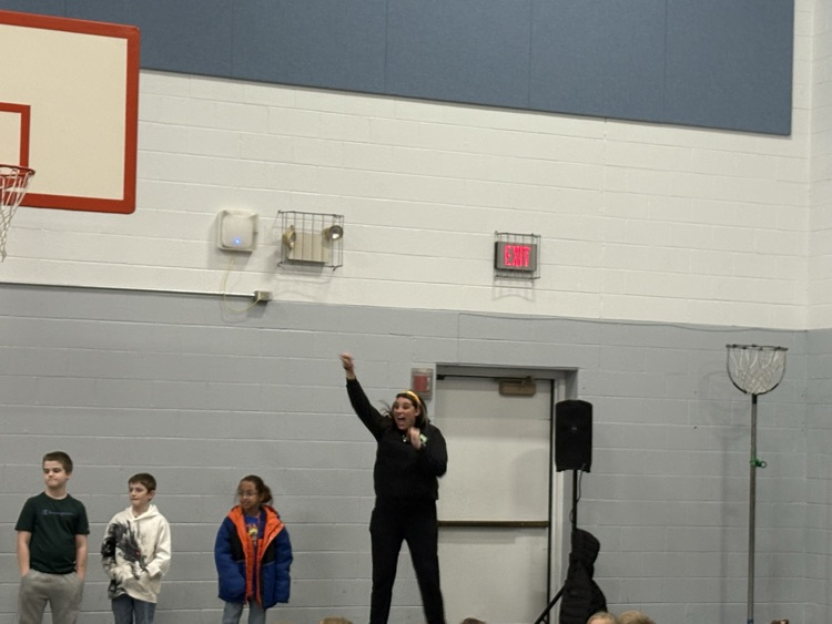 woman raising her arms with kids in front of student body