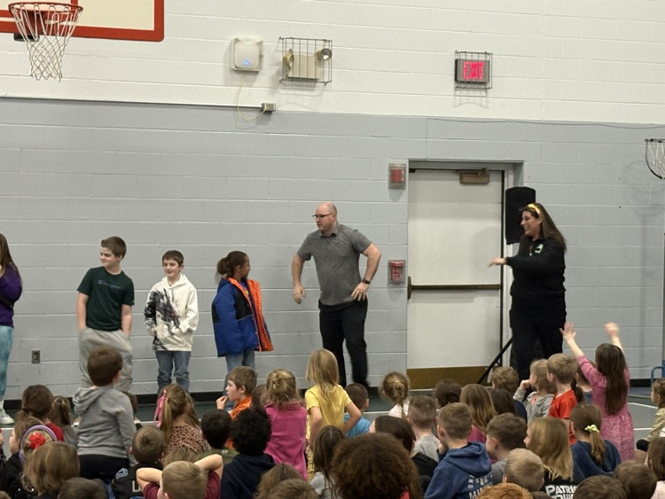 two adults and kids standing in front of audience