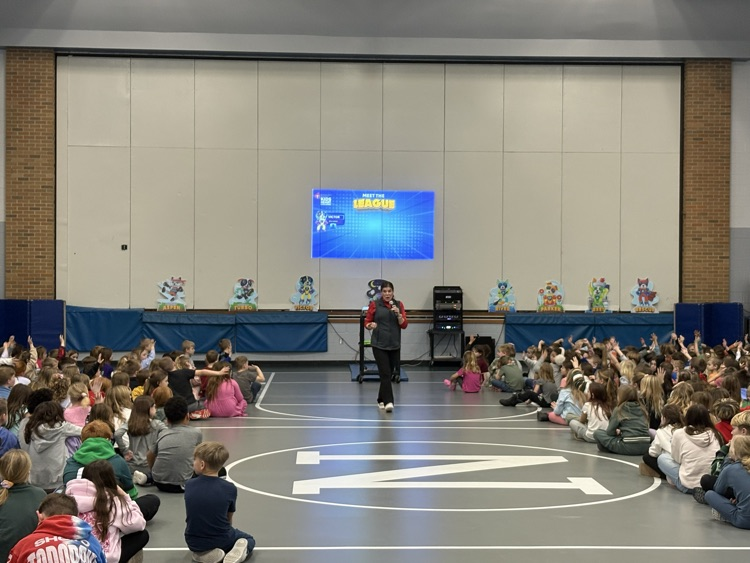 woman speaking to students with screen behind her