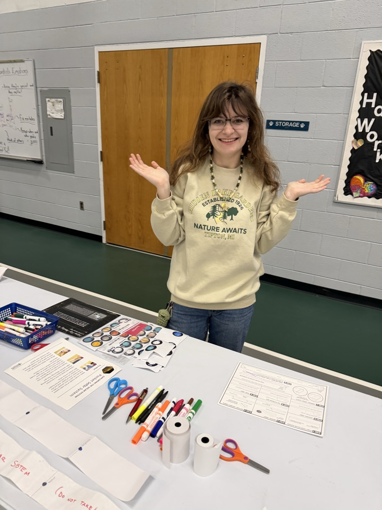 student standing at table of activities 