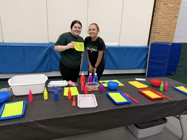two students standing behind a table