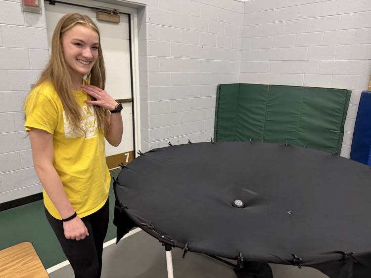 student standing at a black circle device