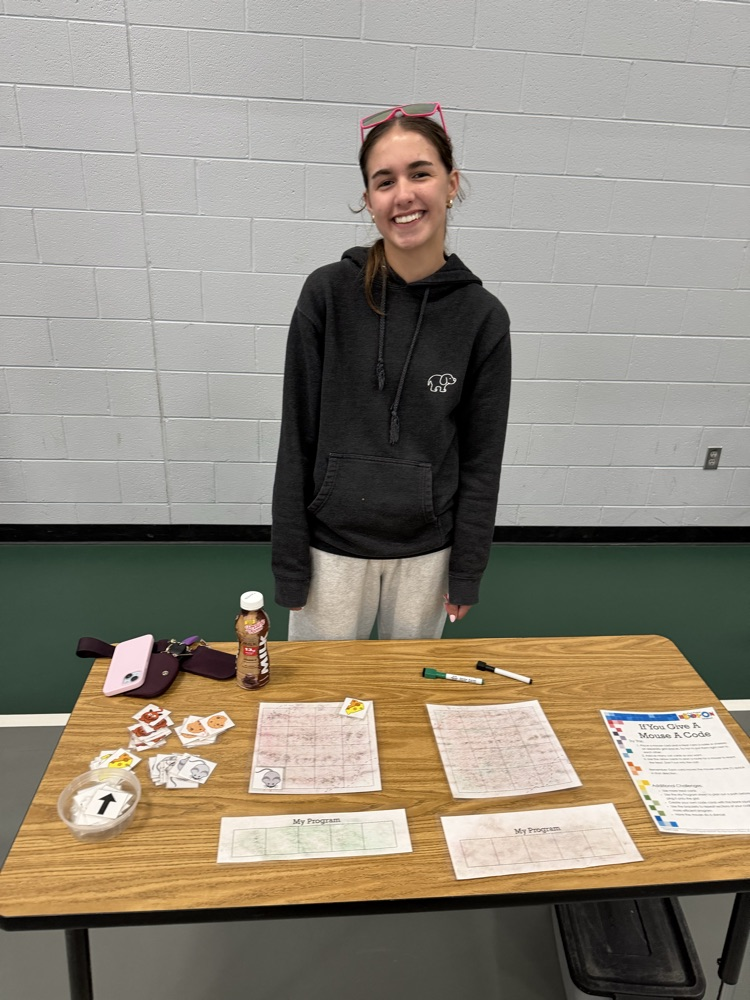 student standing behind a table