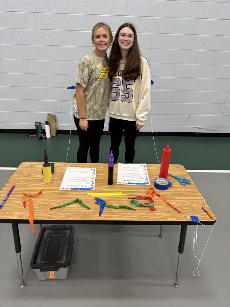 student standing behind a table
