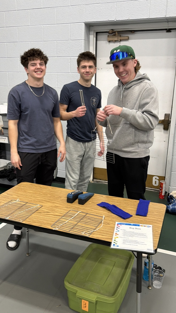 three students standing at a table