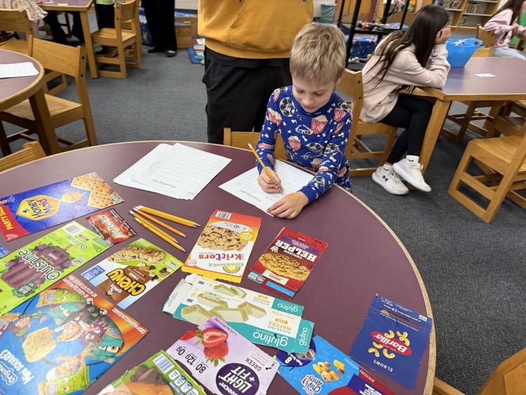 student writing shopping list with food labels 