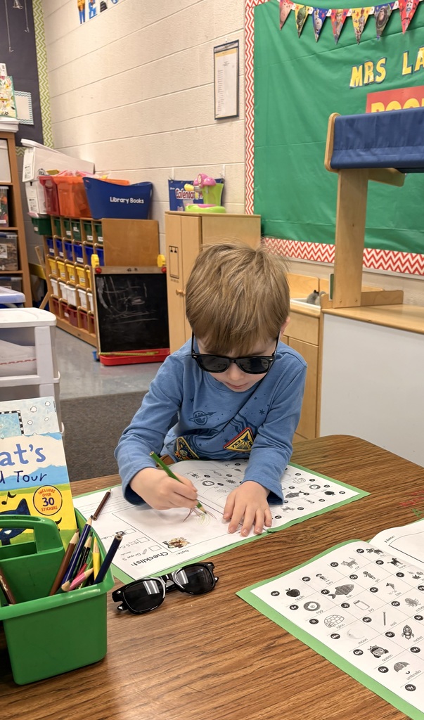 boy with sunglasses on looking at letters