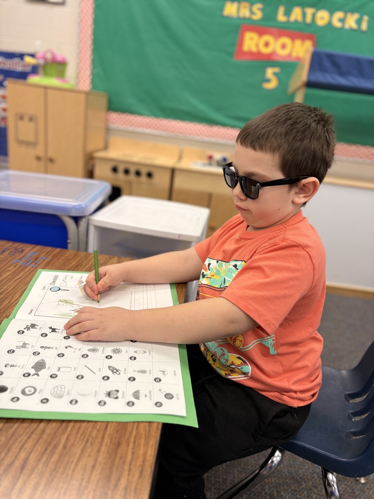 boy with sunglasses on looking at letters