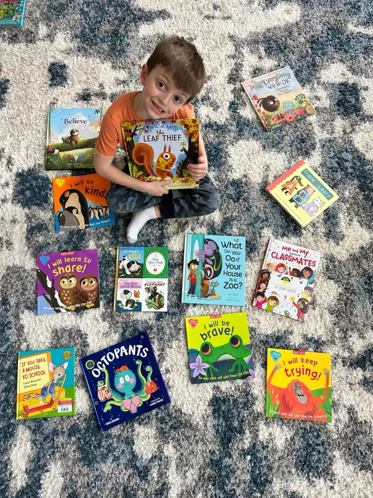 student on rug with books