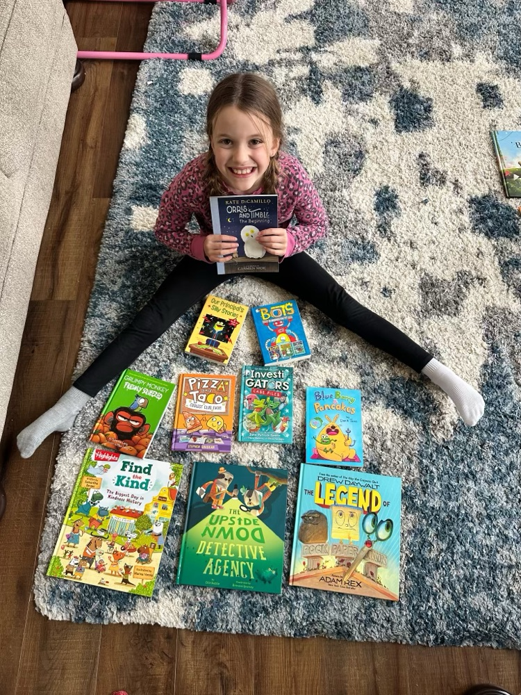student on rug with books