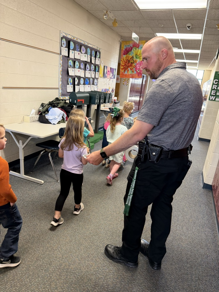 officer handing out stickers to students in a line