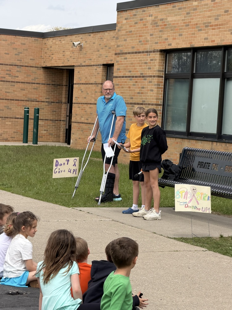 a man with crutches standing by two students 