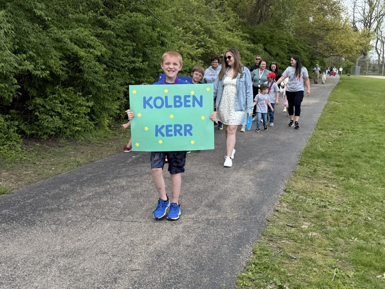 student holding sign on track