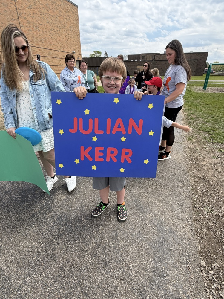 student holding a sign with his name on it