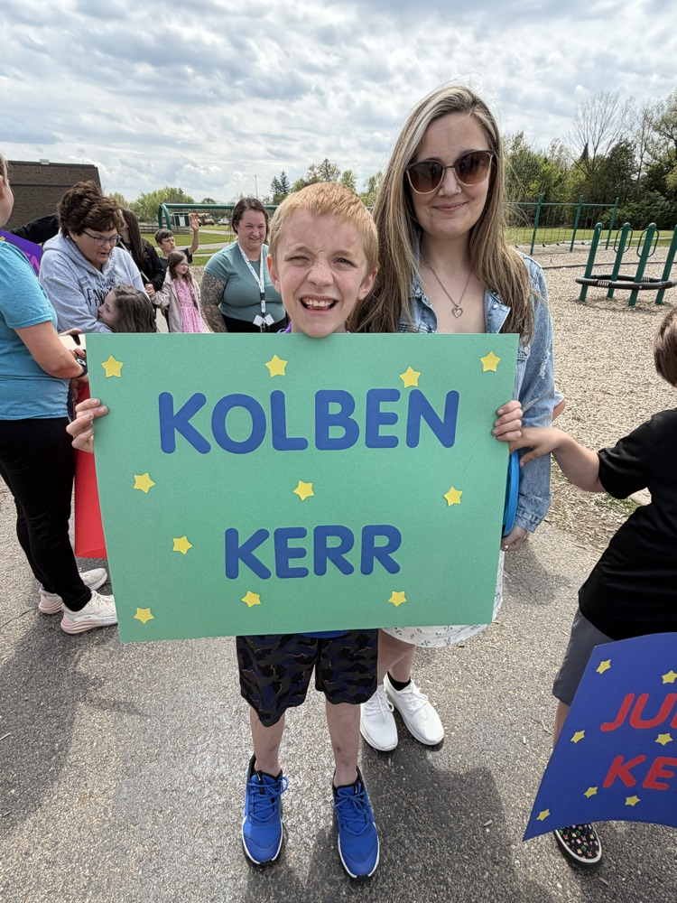 student holding a sign with his name on it