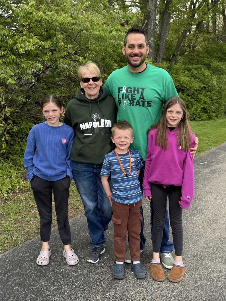 group of five people standing on track for walk