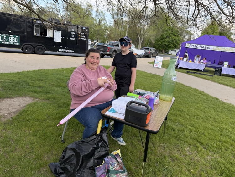 woman sitting at table making balloons with a child