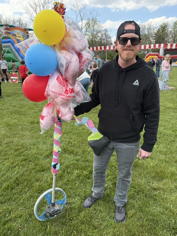 man holding cotton candy on a stick