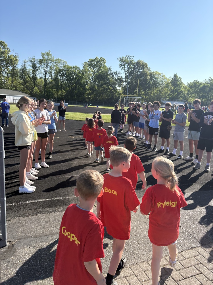 kids in red name shirts walking onto track