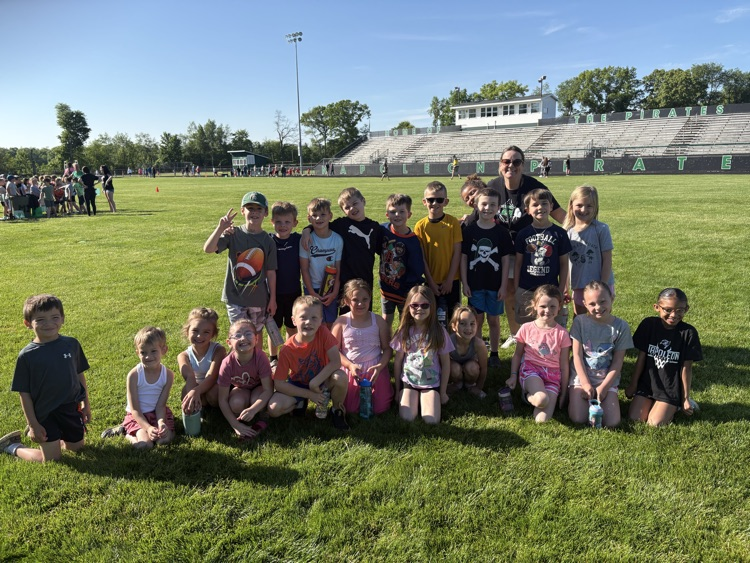 students standing with their teacher at football stadium for field day