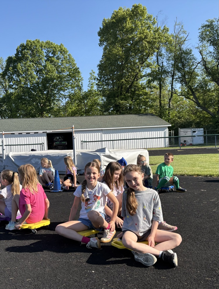 students riding on scooters at field day