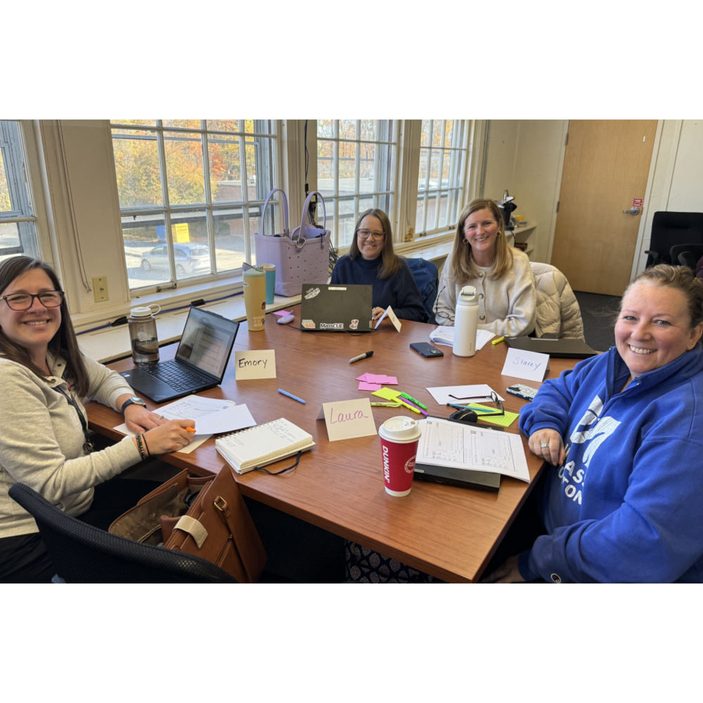 NRSD staff members sit around a table in a conference room during a PD session.