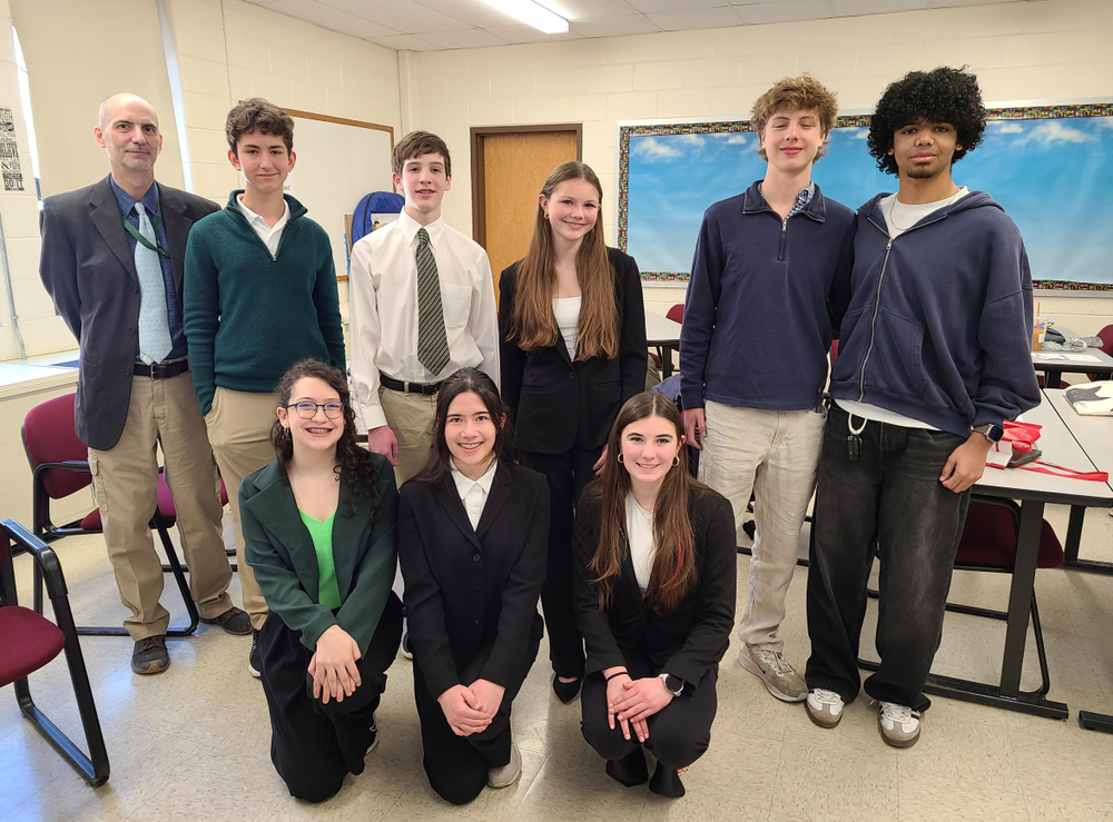 NRHS students and their history teacher pose together for a photo.