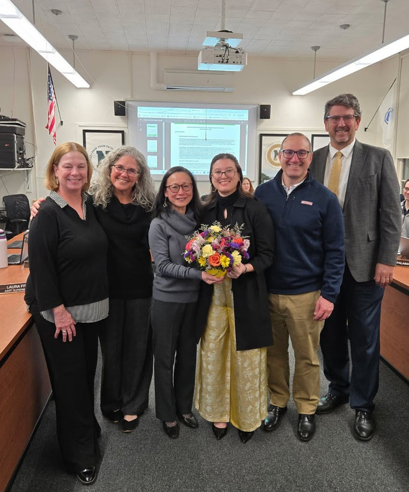 Superintendent Downing and Dr. Boynton pose with the Albanese family during a School Committee meeting.