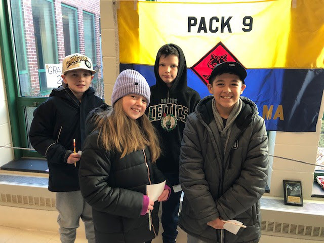 students stand and smile for a group photo in the cafeteria