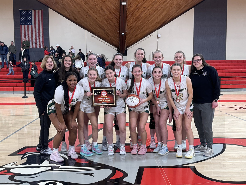 the NRHS girls' basketball team holds an award plaque and poses with their coaches on the court