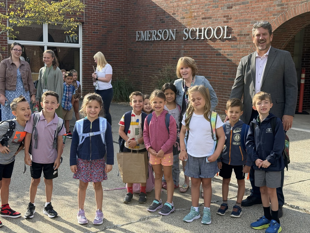 Superintendent Downing stands with a group of students and their teacher as they walk into the Emerson building on the first day.